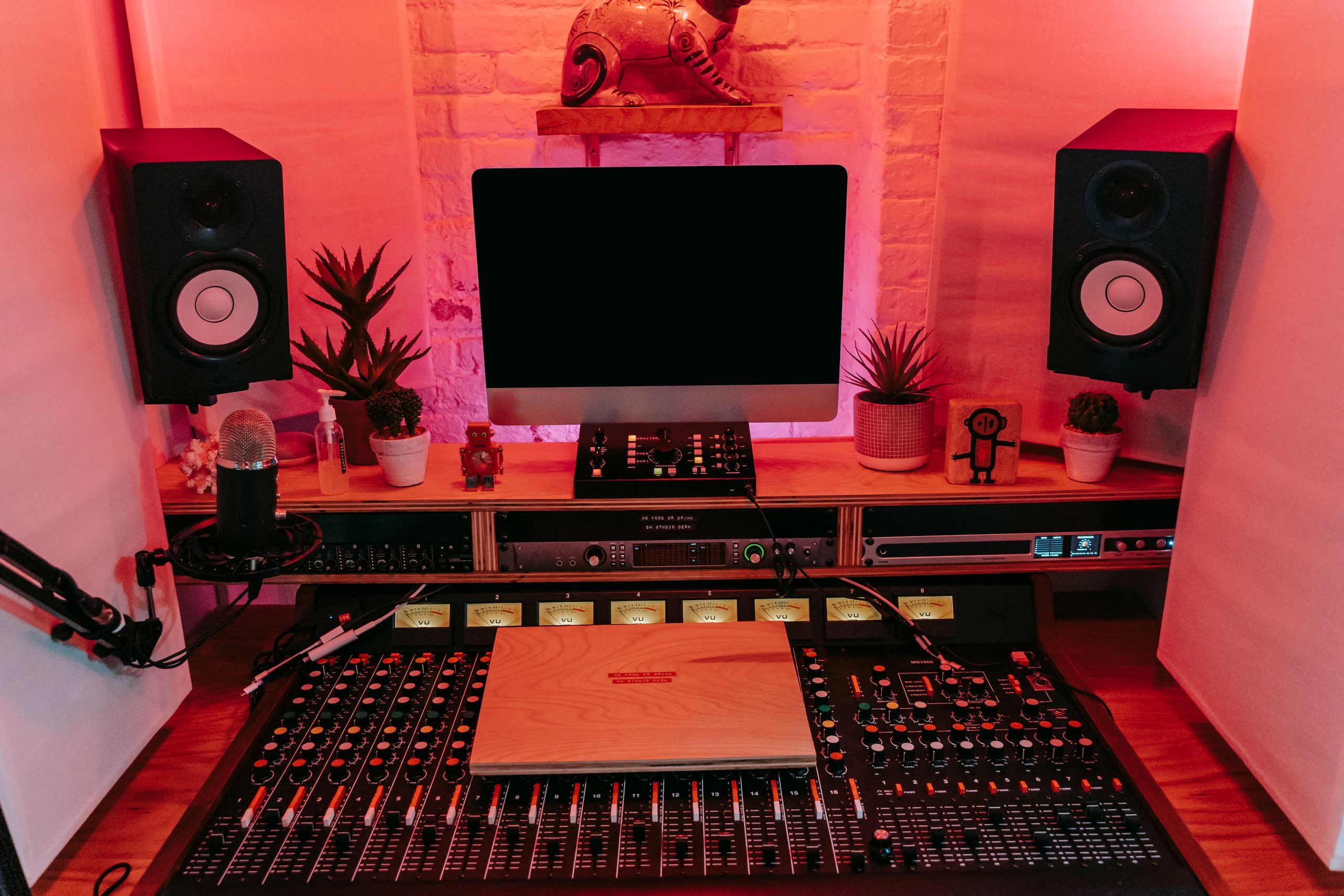 A recording studio room with monitors and a mixing desk